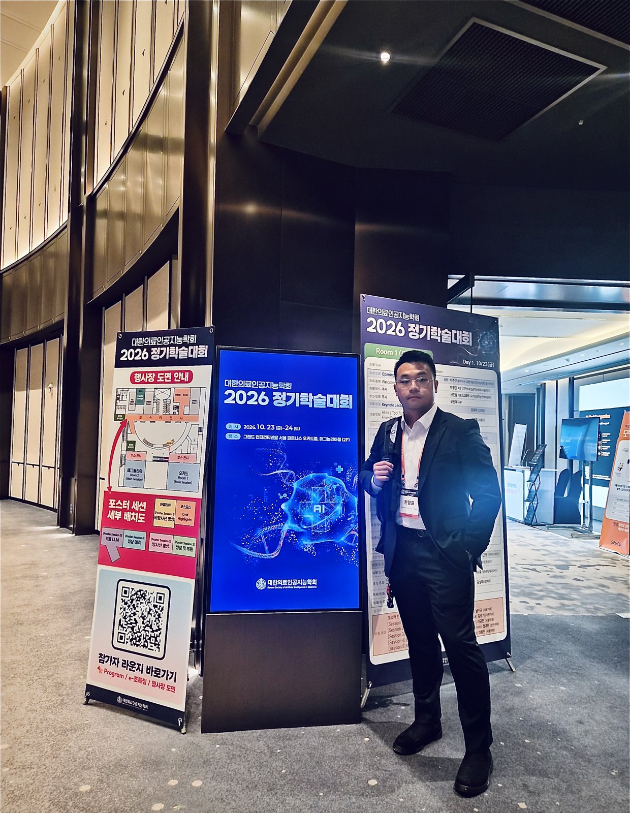 (a) In the lobby, by the conference signage